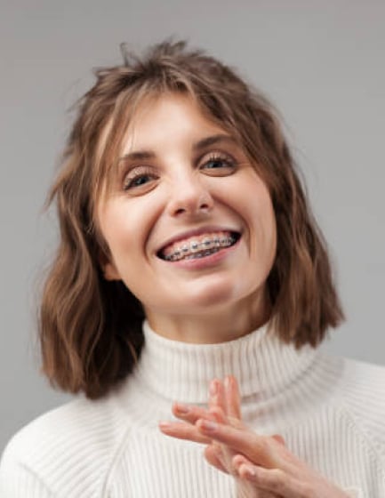 Young woman with ceramic braces smiling, orthodontist in Plano