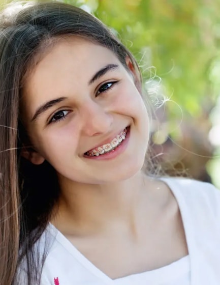 Teen girl smiling with metal braces at Texas Braces, serving Plano