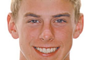Smiling young man with blonde hair in professional headshot for orthodontics practice