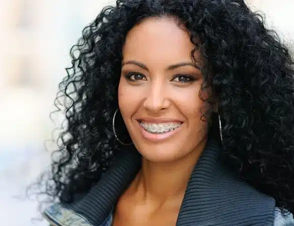 Smiling woman with metal braces at Elvebak Orthodontics, trusted orthodontist in Dallas and Plano