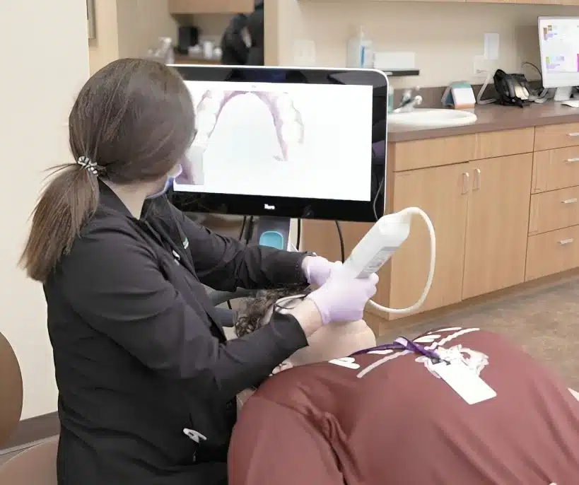 Teen patient holding Invisalign clear aligners at Elvebak Orthodontics in Plano, TX.