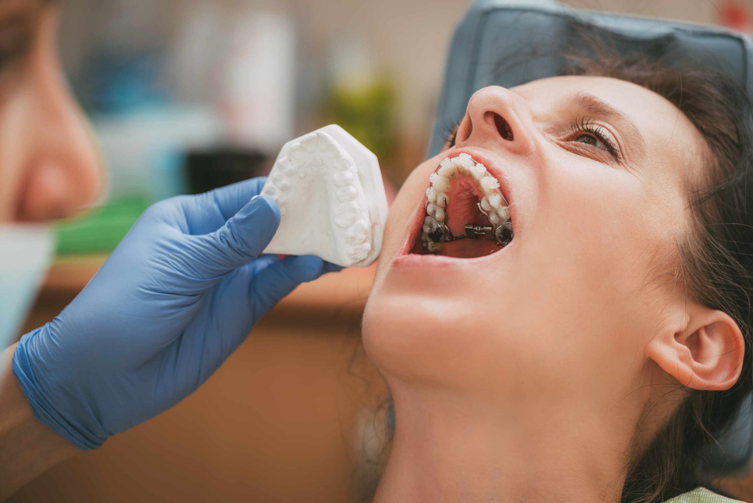 Young patient displays metal braces during orthodontic examination in dental office.